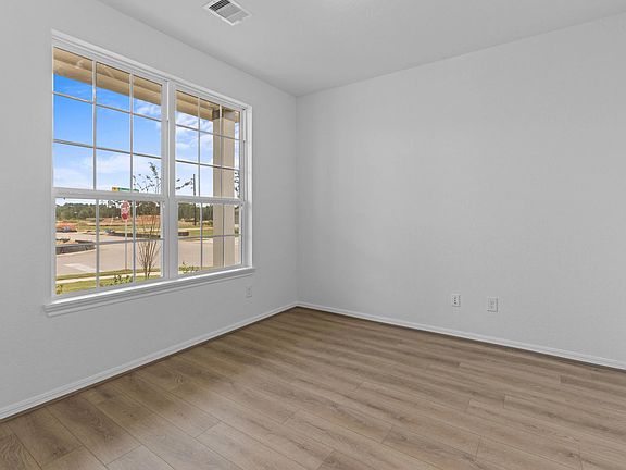 Beautiful front study with elegant flooring and bright windows, offering a quiet space to focus or u