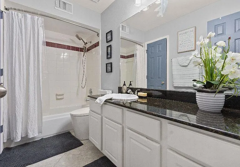 Spacious bathroom with rain shower head, full size bathtub, built-in linen closet, hair dryer, flat iron