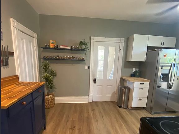 Kitchen with butcher block counters, walk-in pantry, and door leading to laundry and mud room and basement.