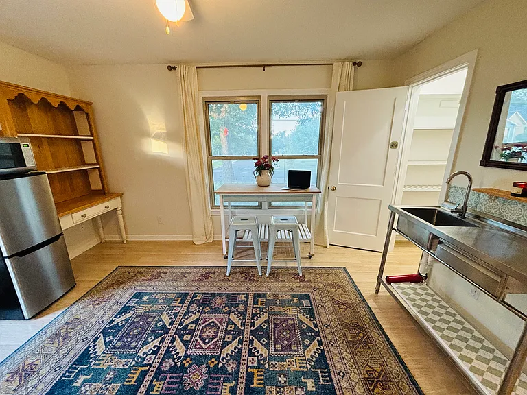 Flexible living area with dining table/kitchen island, pantry, sink, and kitchenette. Perfect for studying, cooking, or relaxing.
