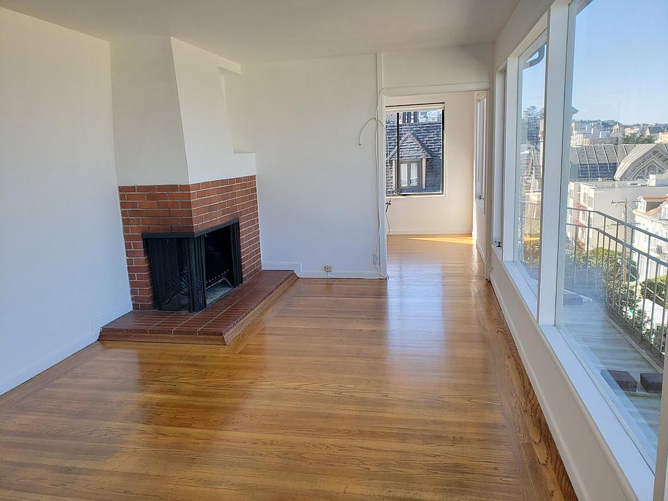 Living room with fireplace. Dining room in the background.