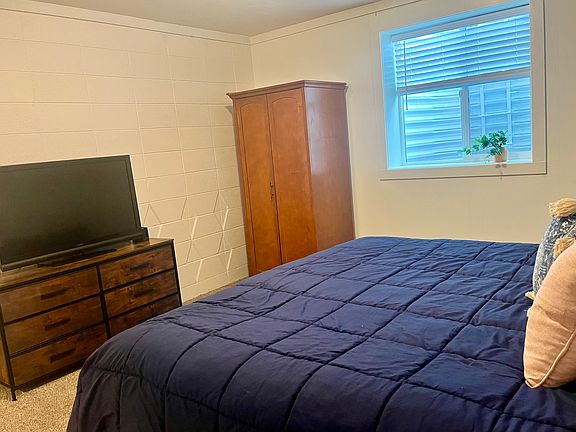 Master bedroom with ensuite bathroom, TV, and amoire
