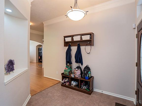 Tile flooring, lighted art niche, high ceilings and lots of crown molding at interior entry.