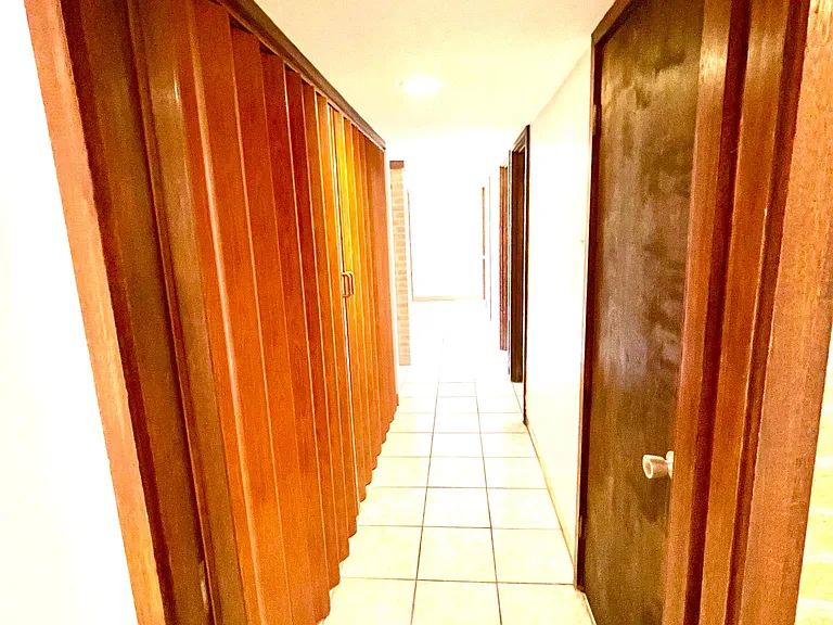 Hallway to laundry area on the left, three bedrooms and two baths