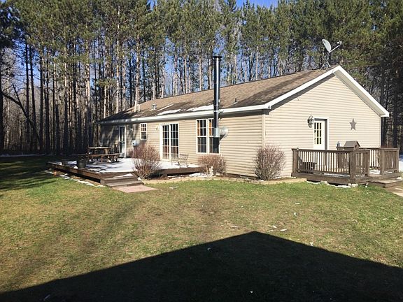 A view of the back of the home, featuring a back deck off the eating area in kitchen.