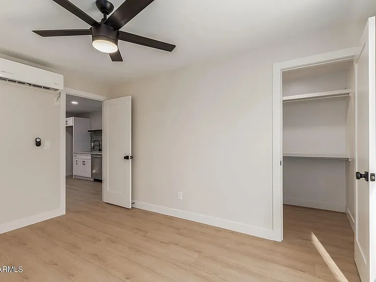 Bedroom with walk in closet. Closet includes full size washer and dryer