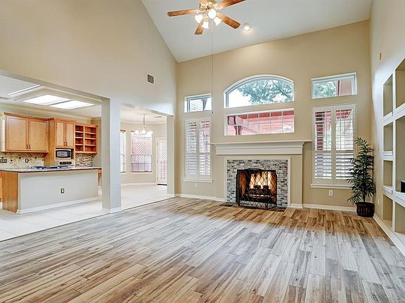 Open and airy, light and bright, the family room/den is perfect to enjoy year around. Entertainment center to the right and open to the deluxe chef's kitchen and inviting breakfast room. Covered flagstone patio out back.