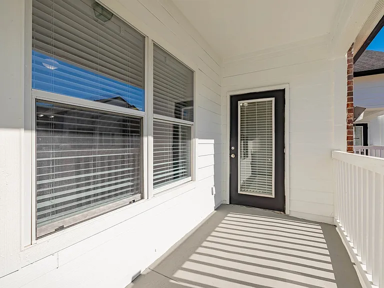 Charming outdoor patio with elegant white railings and large windows, perfect for relaxing under the sun. Charming outdoor patio with elegant white railings and large windows, perfect for relaxing under the sun.