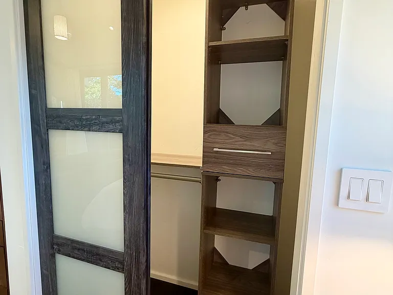 Bedroom closet with 3 hanging bars and build in cabinet.