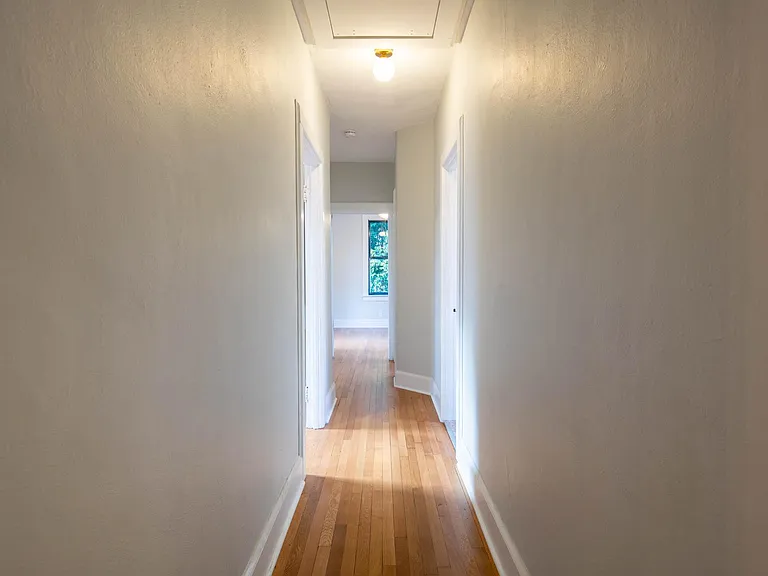 Hallway leading to bedroom 2 on the left, two full bathrooms on the right, and the master bedroom at the end of the hallway