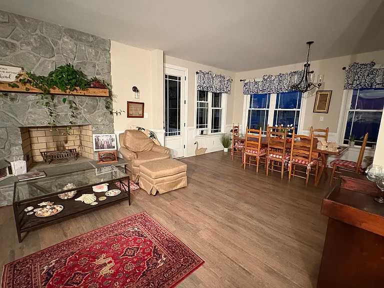 Another view of the living room with the fireplace and dining area.