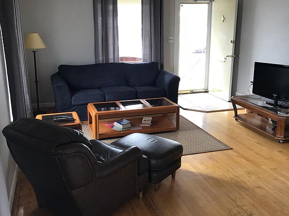 Cozy living room with cable TV and front door leads to cover