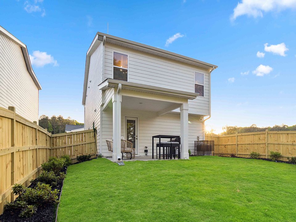 Private fenced yard with lush green space and a covered patio_perfect for morning coffee, quiet evenings, or outdoor dining at sunset