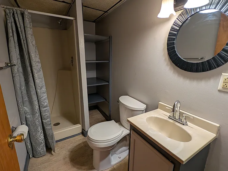 Bathroom with shower and storage shelf