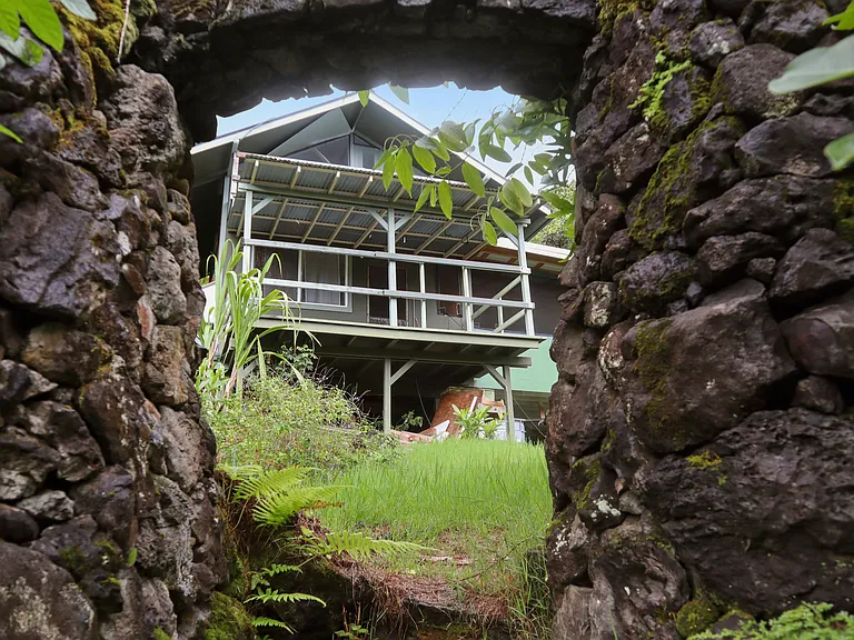 Here's the back view of the cottage through the rock wall. You can see the lanai and the upstairs loft.
