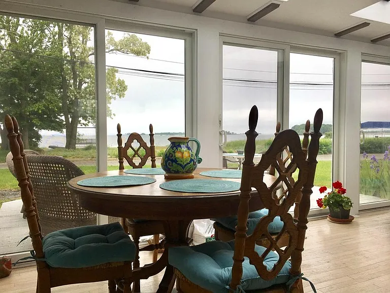 Dining in the sun-filled great room with skylights and panoramic water views (table expands to seat up to 8)