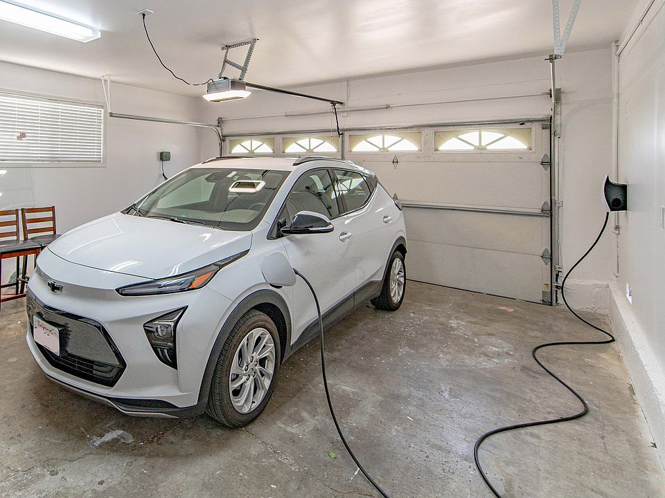 Tesla charging unit in garage includes adapter for other EVs.