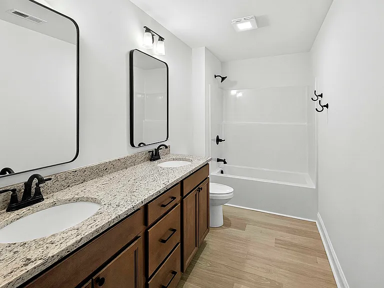 Bath 2 (hall bath) with dual vanity, granite countertops and matte black accessories