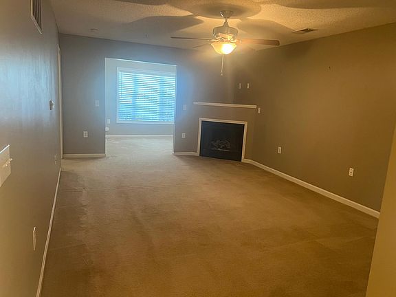 Spacious living room with Fireplace and ceiling fan.