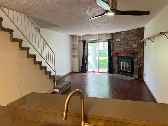 Open lay-out into the freshly painted living and dining space, with ceiling fan, fireplace, and built-in shelves.
