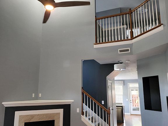 Spacious living room with gas fireplace and two-story ceiling. View is from front door