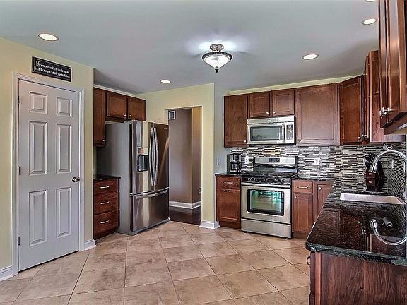 SPACIOUS KITCHEN FEATURES UPGRADED CABINETS, GRANITE, BACK SPLASH, CERAMIC FLOORING & UPGRADED STAIN