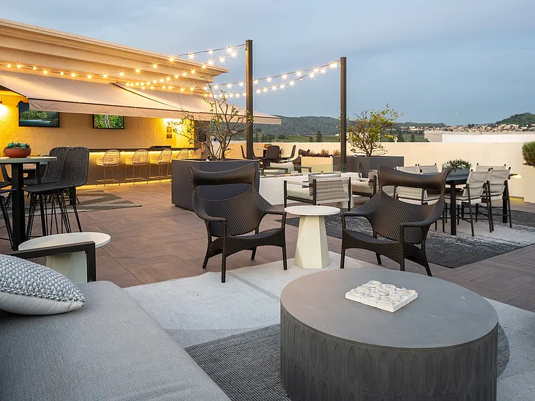 Rooftop SkyLounge with comfortable seating, fire pit, and sun shade