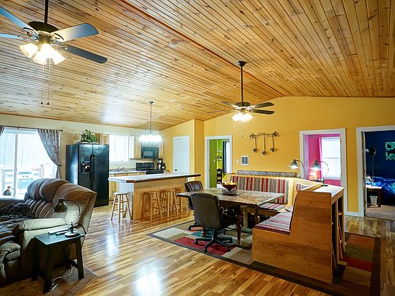 The laminate floors shine and tie all these living areas together. The kitchen window and sliders look out onto the pond just behind the home.