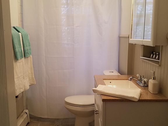 Pretty white bathroom with cabinet for towels and toiletries plus medicine chest and under vanity storage