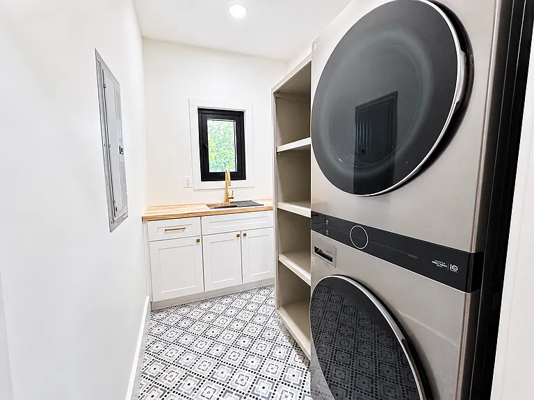 Laundry room with washer, dryer, sink, stocked essentials, and storage for convenient longer stays.