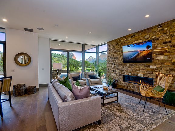 Open Living Room. Linear gas fireplace surrounded by natural stone.