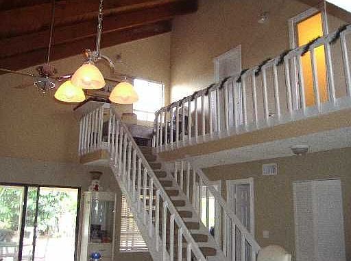 20 ft beamed ceiling and dramatic staircase- lots of light