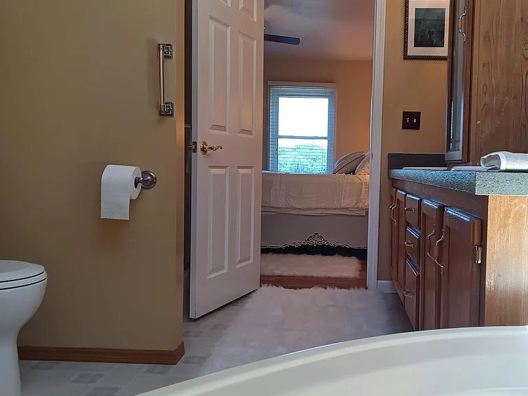 Adjoining handicap friendly Master Bath to Master Bedroom with new countertops, skylight, complete with basic necessities