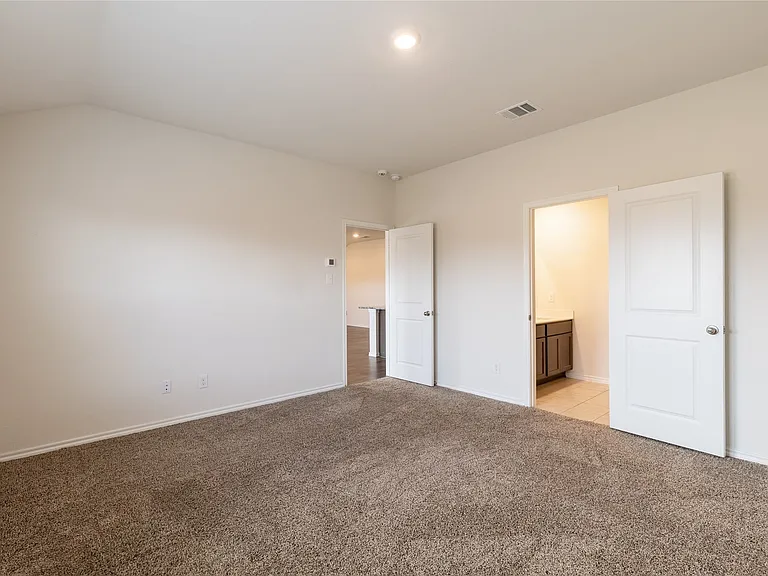 Spacious room featuring light neutral wall paint, and plush carpeting