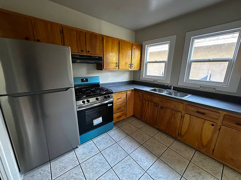 Beutiful kitchen with lots of wood cabinets for storage and cooking.