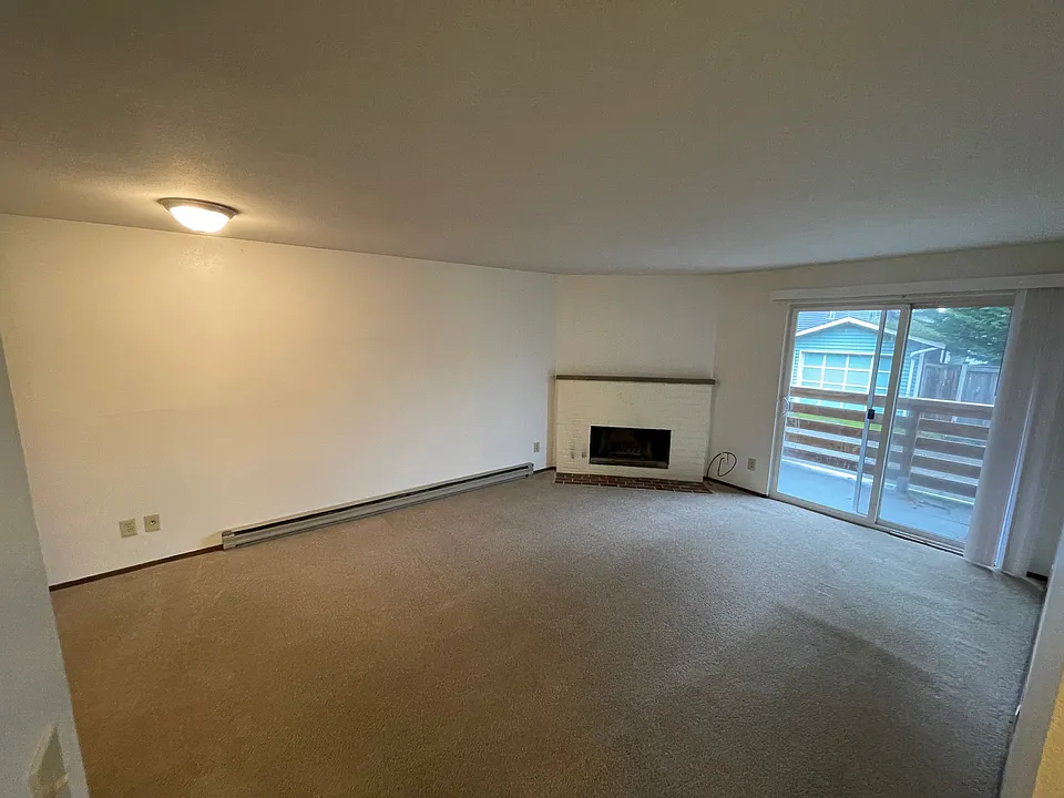 Large bright living room with fireplace and sliding doors to balcony