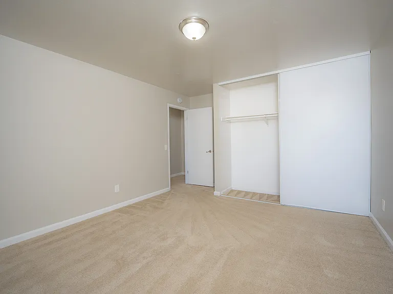 Discover tranquility in this spacious bedroom with ample storage and natural light.