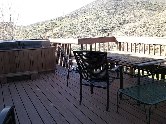 Patio with hot tub. Play set and trampoline in the backyard