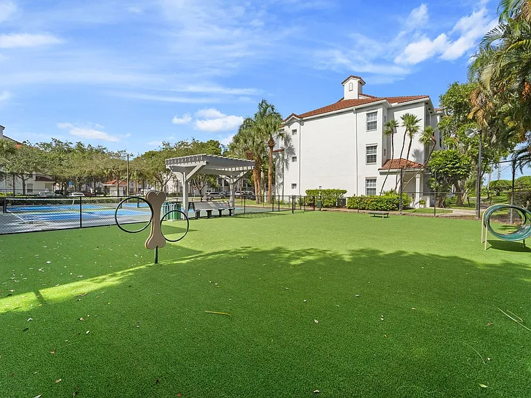 Leash-free dog park with agility games, benches, and lots of grassy area.