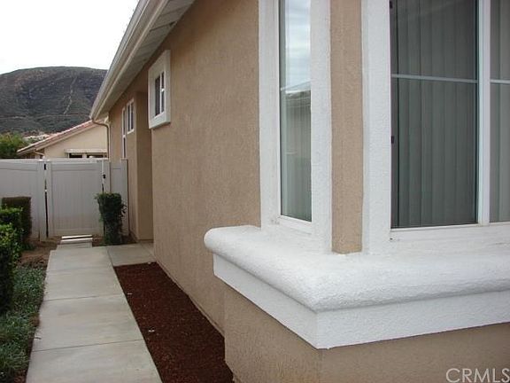 SIDE ENTRANCE TO YOUR HOME. WELL MANICURED LANDSCAPE, VINYL FENCING ALL THE WAY AROUND PROPERTY.
