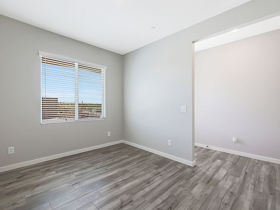 Dining room located off of the entry with large windows and wood-style flooring.