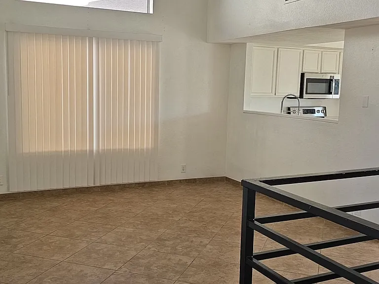 Open entry area featuring high ceilings, abundant natural light, and a spacious layout that flows seamlessly into the living and kitchen areas