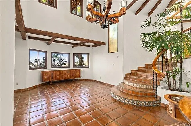 Living room has a vaulted ceiling with a mahogany chandelier. Living room is now furnished.