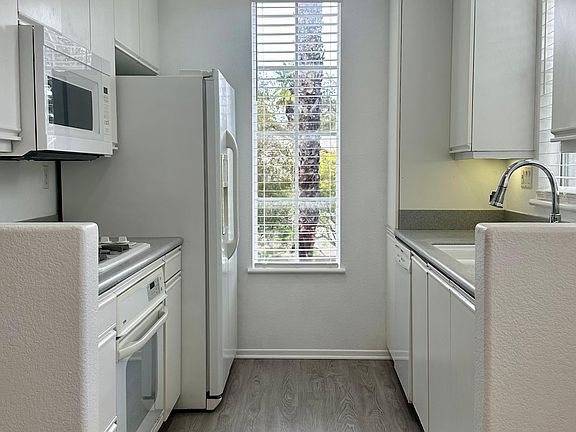 Kitchen has fridge, dishwasher, microwave, gas stovetop and electric oven.