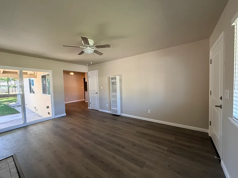 Living room, wall heater, back door, entrance to the kitchen and dining area.