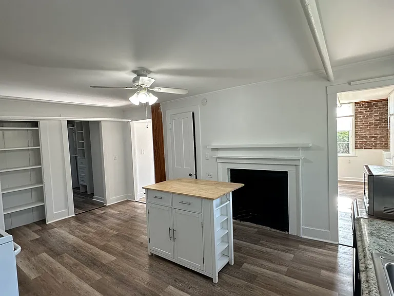 Kitchen facing living room. Kitchen with island (I can provide a 4 seat kitchen table that matches the island) and historic 1853 fireplace.