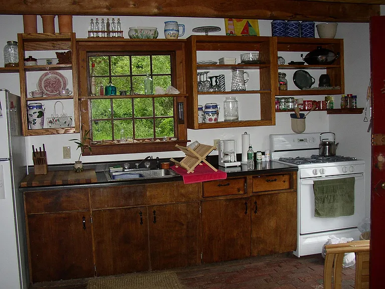 Open shelving in kitchen. Gas cooking stove.