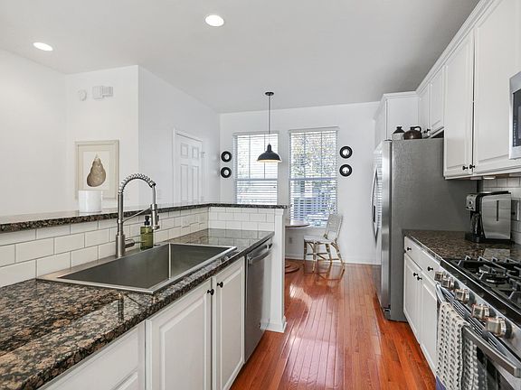 Kitchen opens to Breakfast Room (door on left is Half Bath) and Living Room with Island.