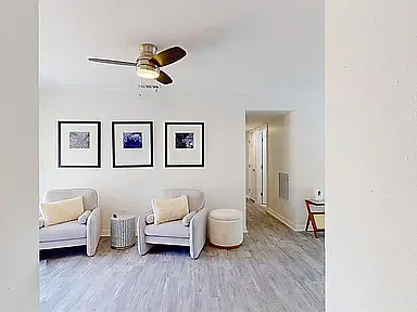 Open-concept living and dining area with hardwood-style floors, ceiling fan, and natural light throughout