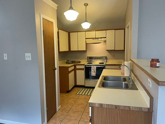 View of kitchen with spacious pantry door on left.